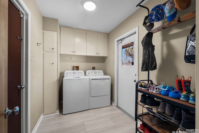 laundry room with cabinets and washing machine and clothes dryer