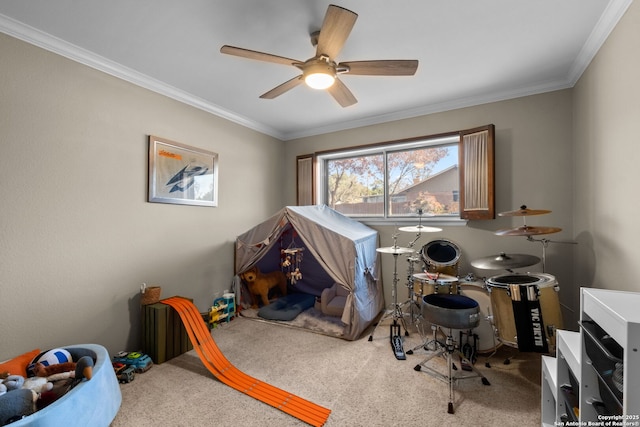 rec room with ceiling fan, ornamental molding, and carpet flooring