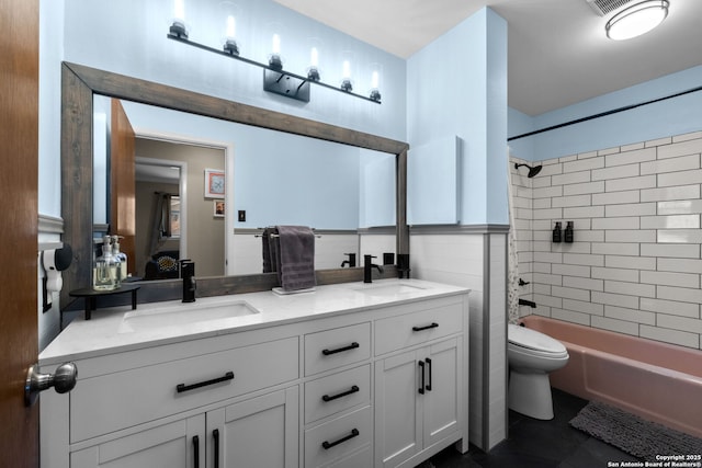 full bathroom featuring tile walls, tile patterned flooring, tiled shower / bath combo, vanity, and toilet