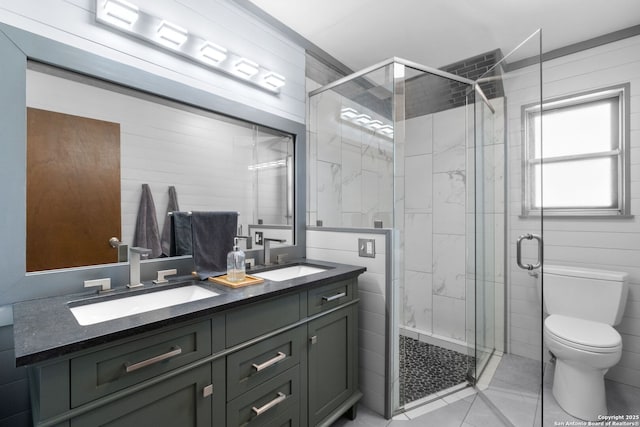 bathroom featuring tile walls, vanity, a shower with shower door, and toilet