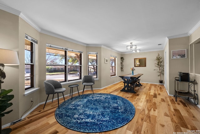 sitting room with crown molding, a chandelier, and hardwood / wood-style floors