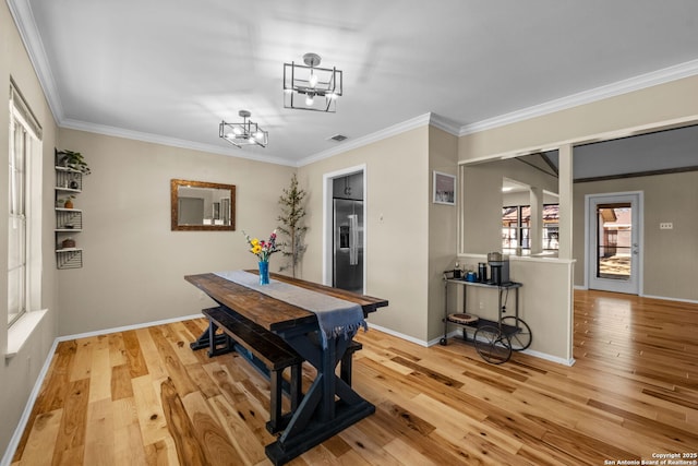 dining area with ornamental molding and light wood-type flooring