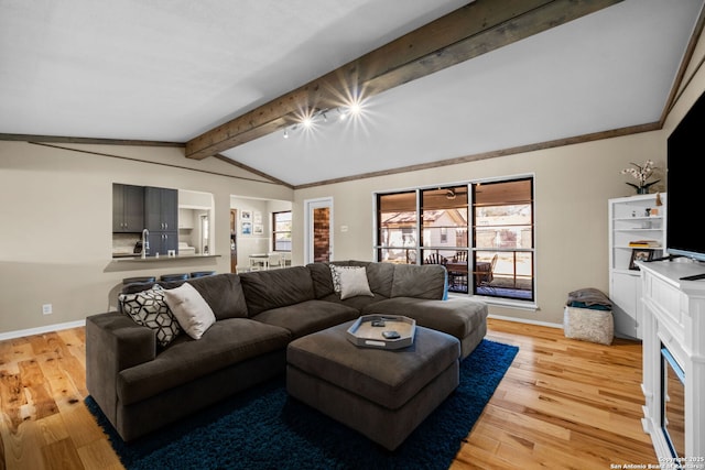 living room with light hardwood / wood-style floors and lofted ceiling with beams