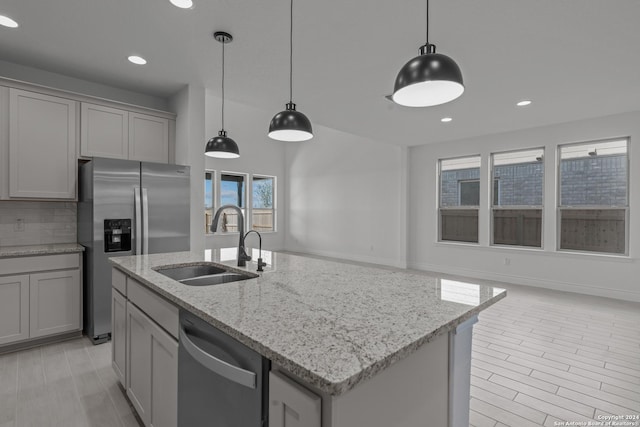 kitchen with appliances with stainless steel finishes, decorative light fixtures, sink, and gray cabinetry