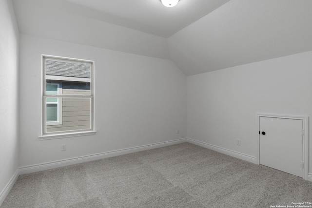 bonus room featuring light colored carpet and vaulted ceiling