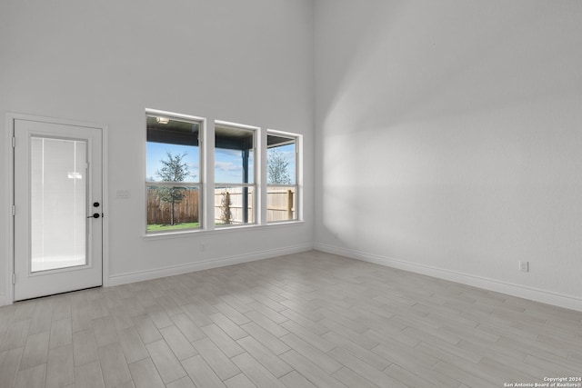 interior space featuring light hardwood / wood-style flooring and a high ceiling