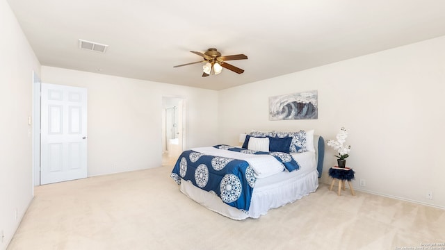 carpeted bedroom featuring ceiling fan and ensuite bath