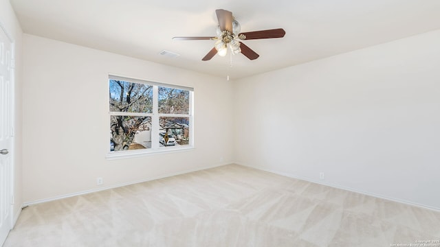 empty room featuring ceiling fan and light carpet