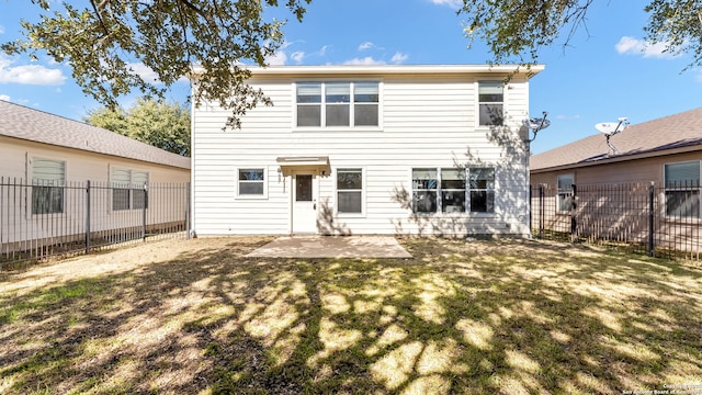 rear view of house featuring a yard and a patio