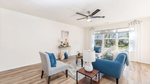 living area with ceiling fan and light hardwood / wood-style flooring