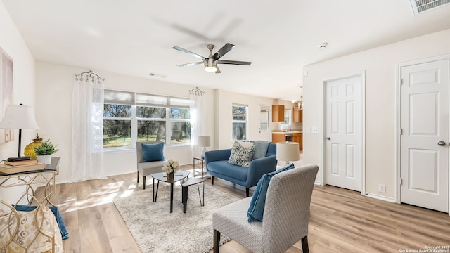 living room with ceiling fan and light hardwood / wood-style floors