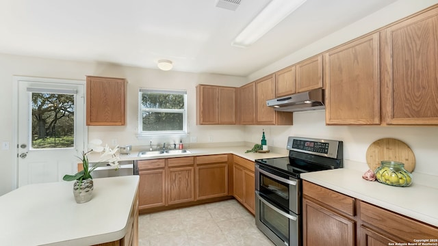 kitchen with range with two ovens, dishwasher, and sink