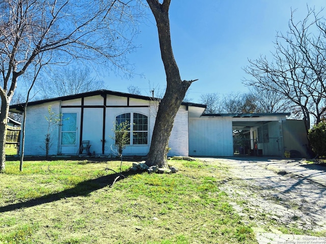 back of house featuring a carport and a yard