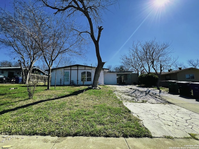 ranch-style house featuring a carport and a front lawn