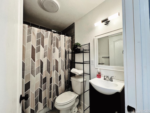 bathroom featuring vanity, walk in shower, a textured ceiling, and toilet