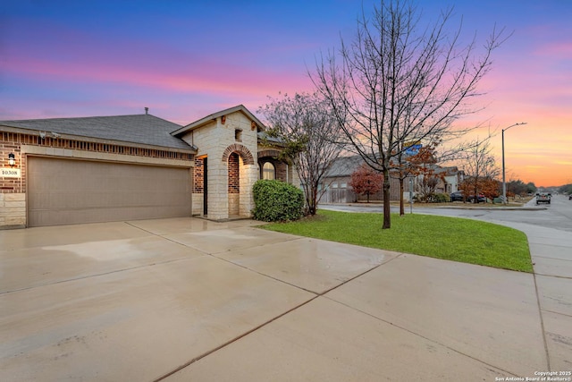 view of front of property featuring a garage and a lawn