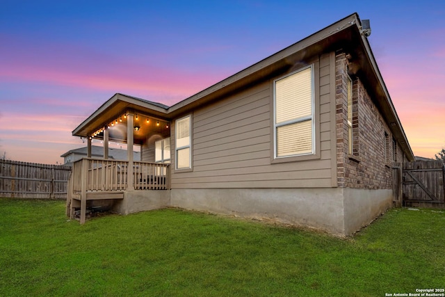 property exterior at dusk with a lawn