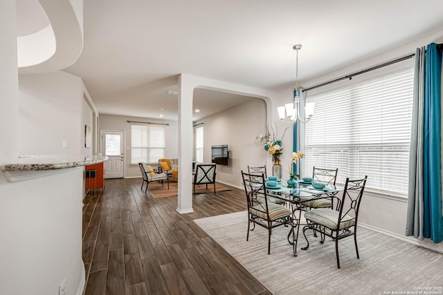 dining room with dark hardwood / wood-style floors and a chandelier