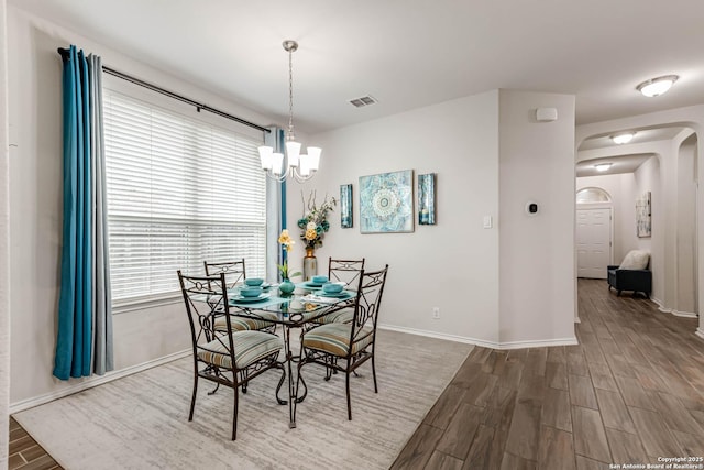 dining space featuring a notable chandelier and dark wood-type flooring