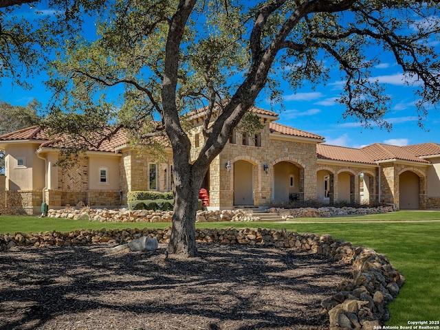 mediterranean / spanish house featuring a front lawn