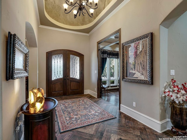 entrance foyer with crown molding, a notable chandelier, dark parquet flooring, french doors, and a raised ceiling