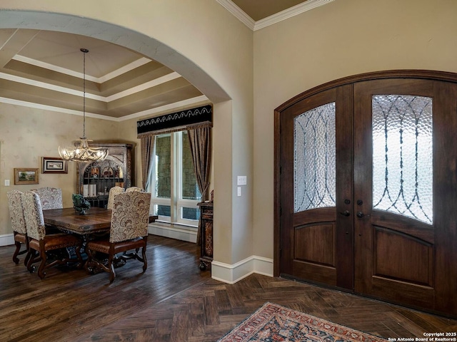 entryway featuring ornamental molding, a wealth of natural light, dark parquet floors, and french doors