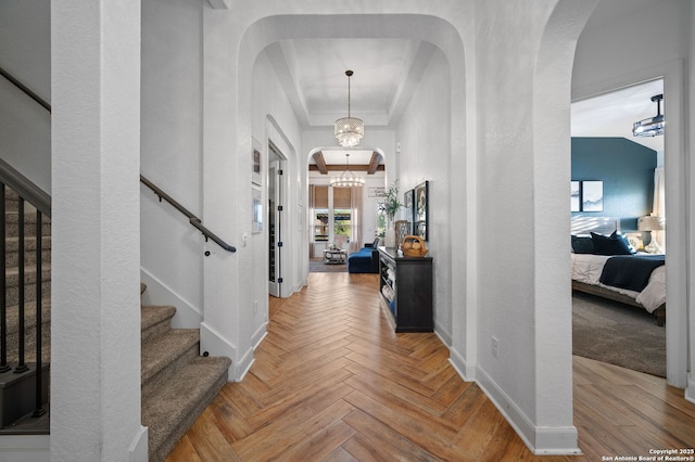 foyer featuring parquet floors, crown molding, and a notable chandelier