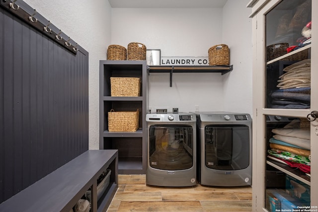 washroom with washing machine and dryer and light hardwood / wood-style floors