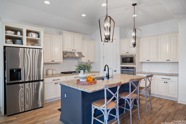 kitchen featuring a kitchen island with sink, sink, stainless steel appliances, and light hardwood / wood-style floors