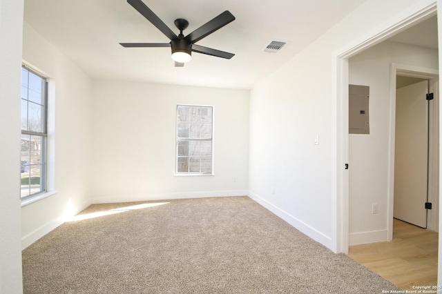 carpeted empty room featuring ceiling fan and electric panel