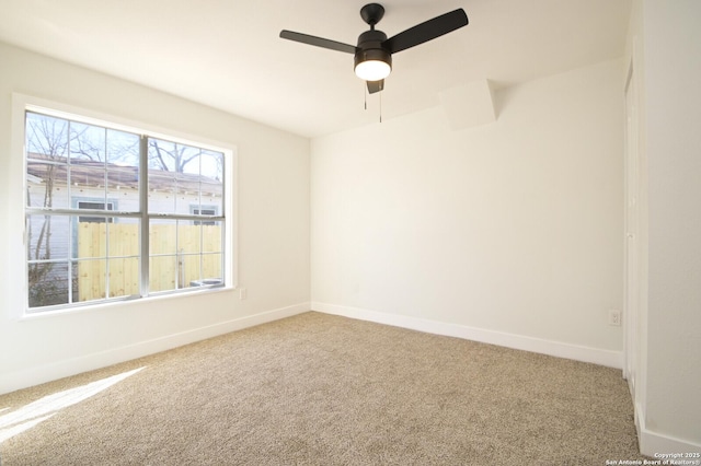 carpeted spare room featuring ceiling fan