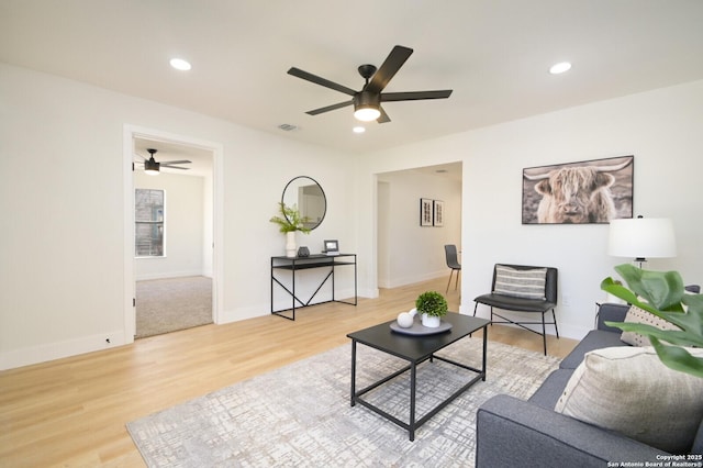 living room with wood-type flooring and ceiling fan