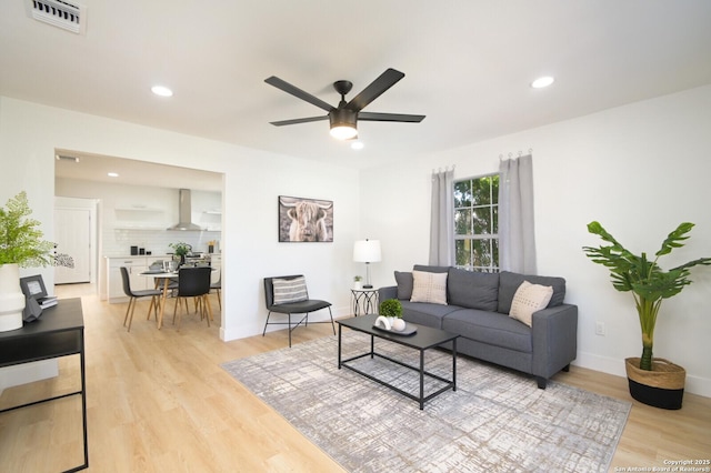 living room with light hardwood / wood-style floors and ceiling fan