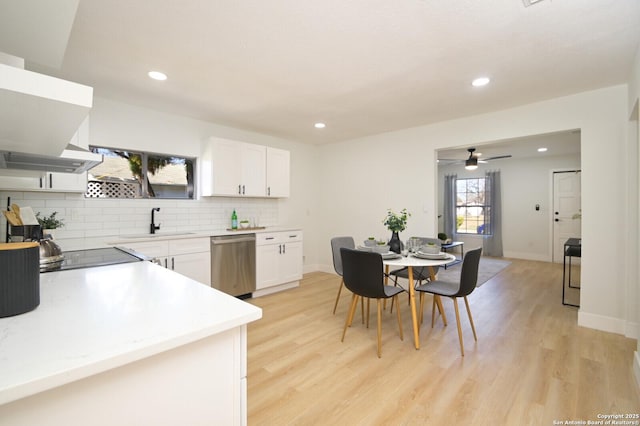 kitchen with white cabinetry, dishwasher, sink, decorative backsplash, and light wood-type flooring