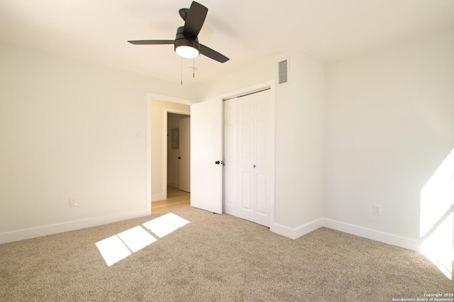 unfurnished bedroom with light carpet, ceiling fan, and a closet