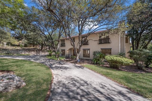 mediterranean / spanish home featuring a front lawn