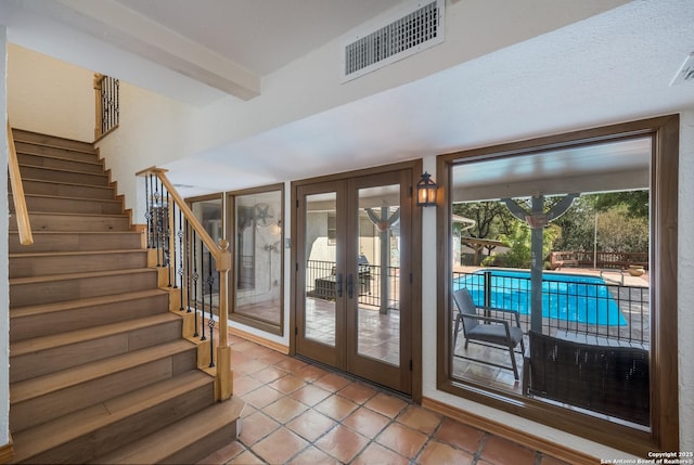 doorway to outside with french doors, tile patterned flooring, and beamed ceiling