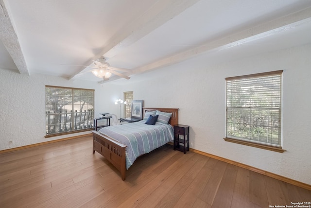 bedroom with beamed ceiling, ceiling fan, and light hardwood / wood-style flooring