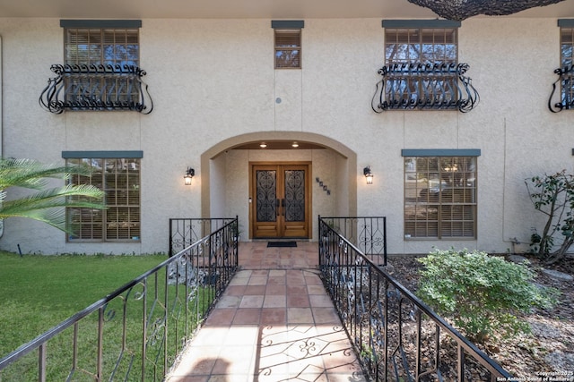 entrance to property with a yard and french doors