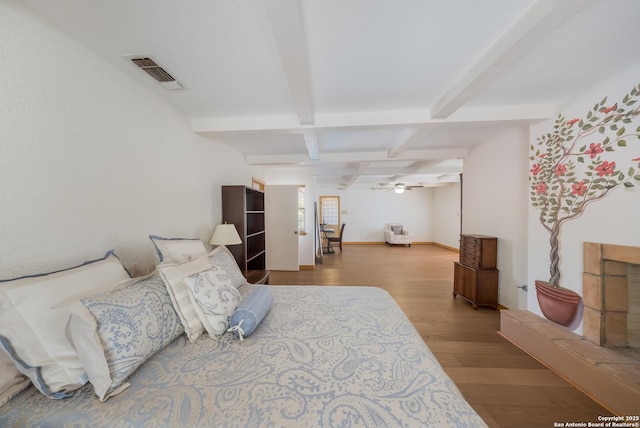 bedroom featuring beamed ceiling, coffered ceiling, and hardwood / wood-style floors