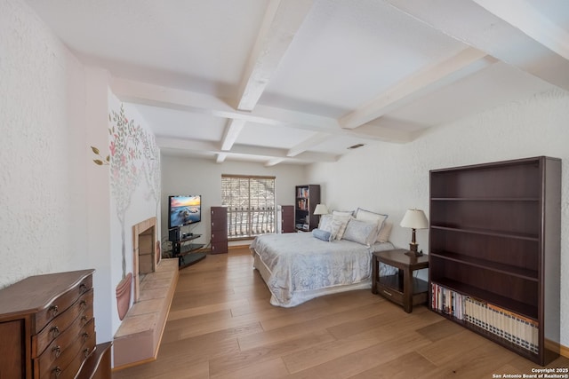 bedroom featuring beamed ceiling, coffered ceiling, and light hardwood / wood-style flooring