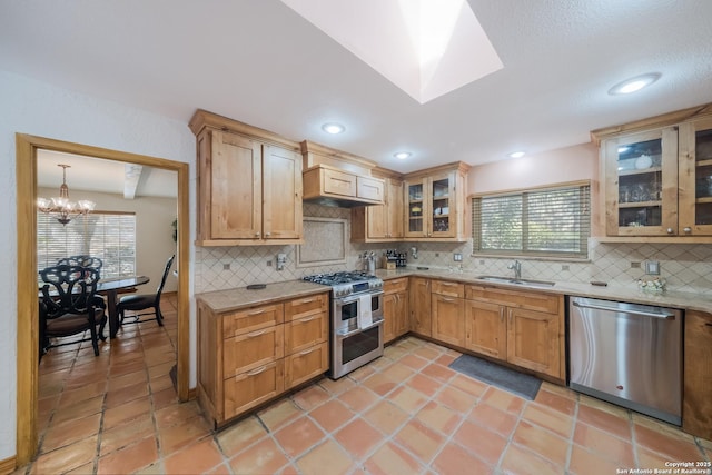 kitchen with sink, decorative light fixtures, plenty of natural light, stainless steel appliances, and decorative backsplash