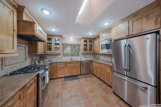 kitchen featuring sink, light tile patterned floors, stainless steel appliances, light stone counters, and tasteful backsplash