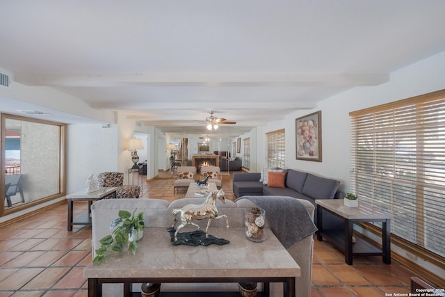 tiled living room featuring ceiling fan and beam ceiling