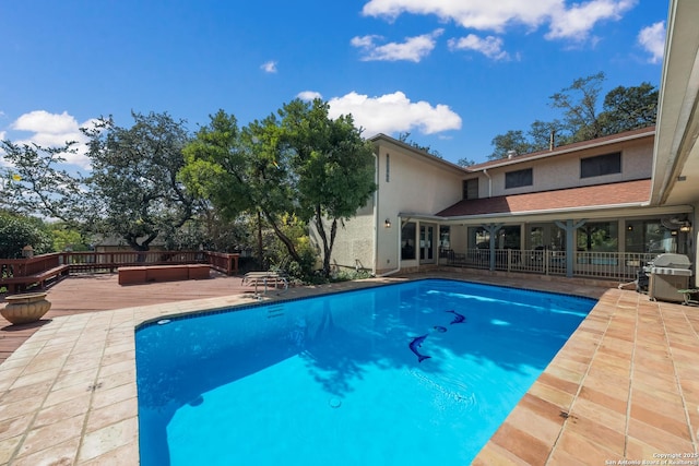 view of pool with a grill and a deck