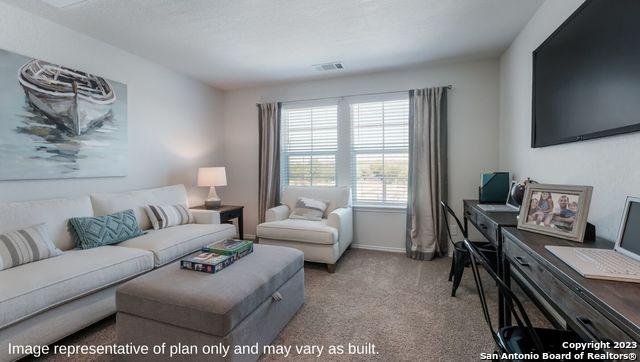 living area featuring carpet floors, baseboards, and visible vents