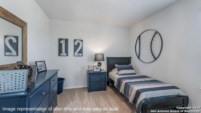 bedroom with light colored carpet and baseboards