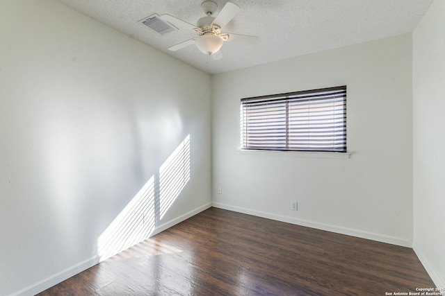 spare room with a textured ceiling, dark hardwood / wood-style floors, and ceiling fan