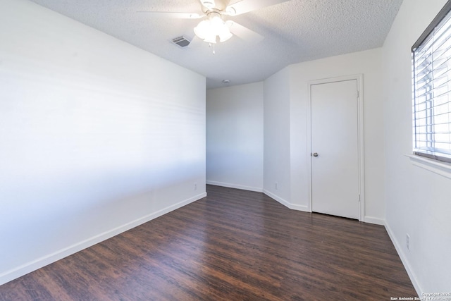 empty room featuring ceiling fan, dark hardwood / wood-style flooring, and a textured ceiling