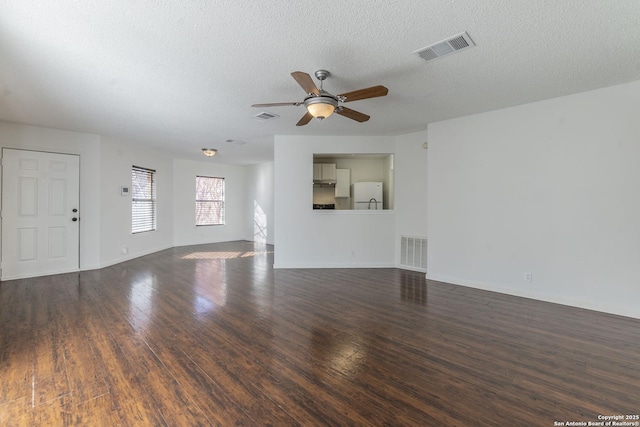 unfurnished living room with dark hardwood / wood-style flooring, a textured ceiling, and ceiling fan